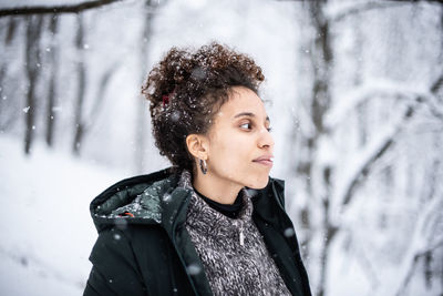 Portrait of young woman standing in snow