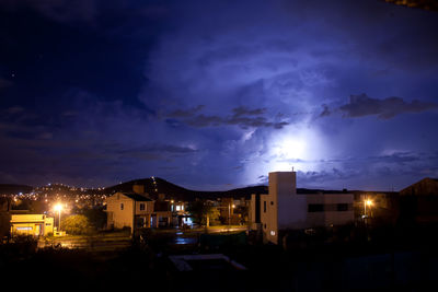 Illuminated buildings against sky at night