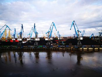 Boats moored at harbor against sky