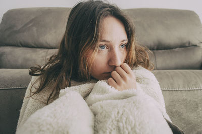 Portrait of woman lying on sofa at home