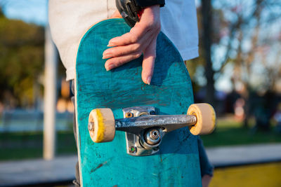 Close-up hand holding skateboard