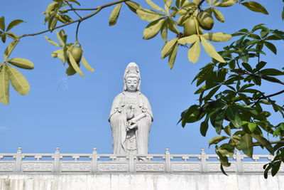 Low angle view of statue against clear blue sky