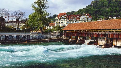 River flowing amidst buildings against sky