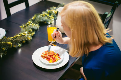 Woman eating food at home during christmas