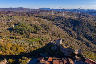 Drone aerial panorama of historic village of sortelha with castle and with turbines