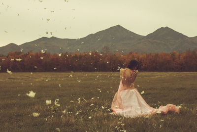 Rear view of woman on landscape against sky