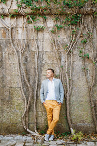 Portrait of man leaning on wall