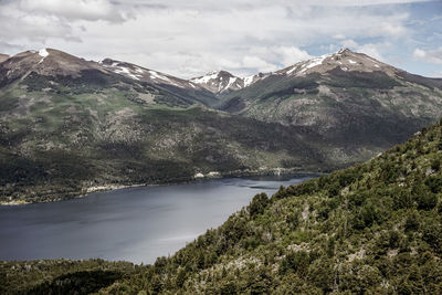 Scenic view of mountains and lake against cloudy sky