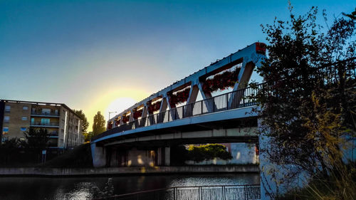 Low angle view of bridge over river against sky during sunset