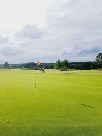 Scenic view of golf course against sky