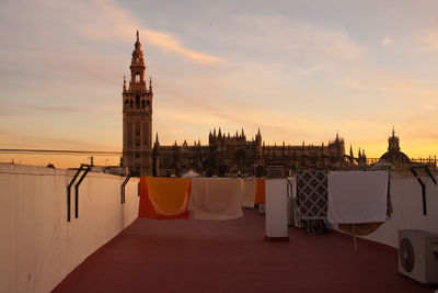 Buildings in city against sky during sunset