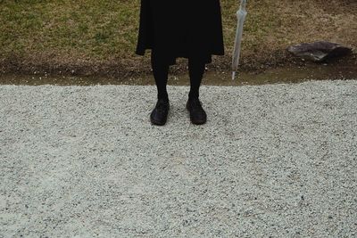 Low section of woman standing on footpath