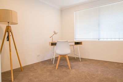 Empty chairs and table against wall at home