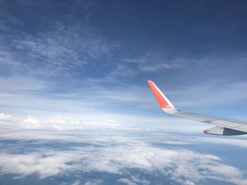 Airplane flying over clouds against blue sky