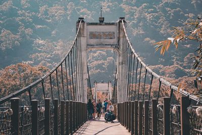 Rear view of people walking on footbridge