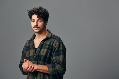 Young man standing against wall