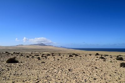 Scenic view of desert against blue sky