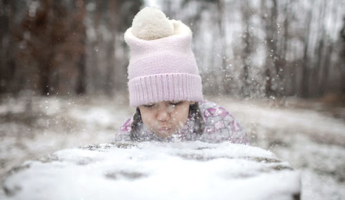 Girl blowing snow during winter