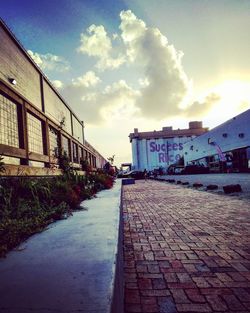 Footpath amidst buildings against sky in city