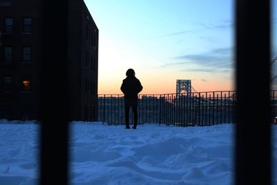 Full length of silhouette person standing against george washington bridge during winter