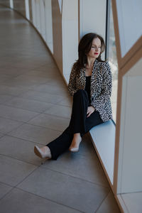 Portrait of young woman sitting on hardwood floor