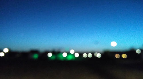 Defocused lights against sky at night