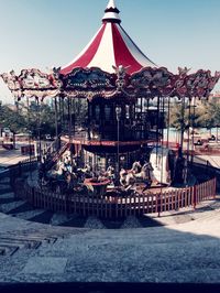 Carousel in amusement park against clear sky