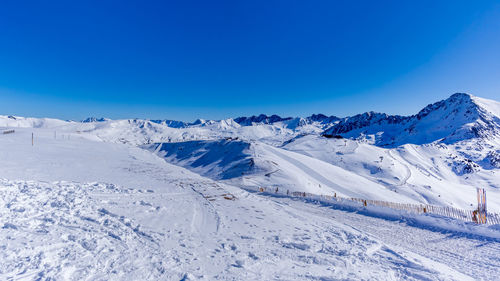 Scenic view of snowcapped mountains against clear blue sky