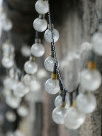 Close-up of string lights on outside of stone building