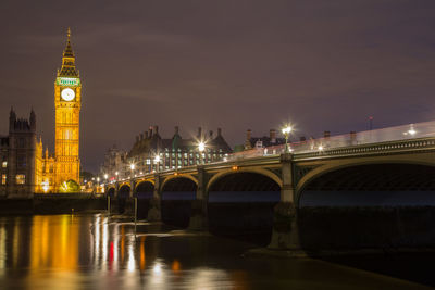 Illuminated city buildings against sky at night