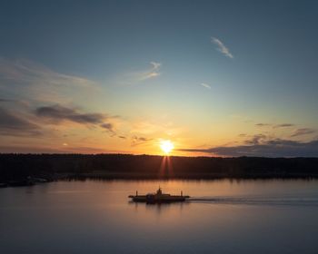 Silhouette boat in sea against sky during sunset