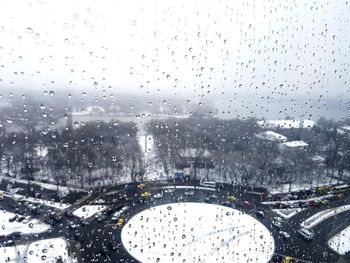 City seen through wet glass window during rainy season