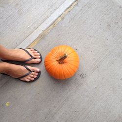 Low section of person standing pumpkin on floor