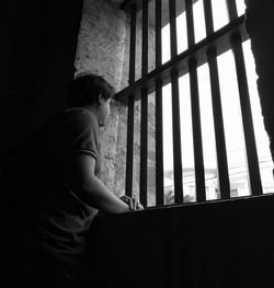 Low angle view of man standing against window at home