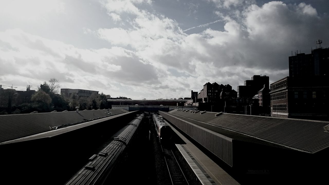 building exterior, architecture, built structure, sky, city, the way forward, cloud - sky, vanishing point, railroad track, diminishing perspective, cloud, high angle view, transportation, cityscape, cloudy, outdoors, roof, day, residential district, no people