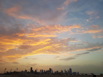 Panoramic view of buildings against cloudy sky