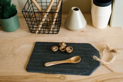 Walnuts on a slate black cutting board and a wooden spoon on the kitchen countertop