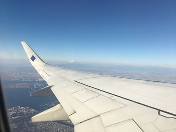 Airplane wing against clear blue sky