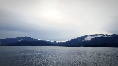 Scenic view of lake by mountains against sky