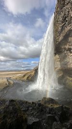 Scenic view of waterfall against sky