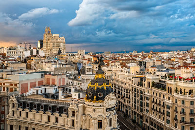 Buildings in city against cloudy sky