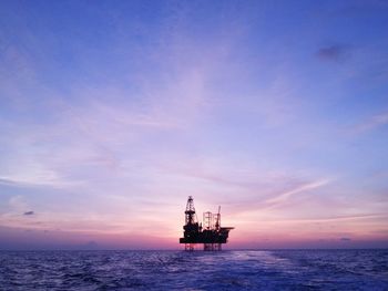 Boat sailing in sea at sunset