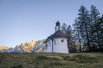 Church by building against clear sky