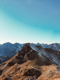 Scenic view of snowcapped mountains against clear blue sky