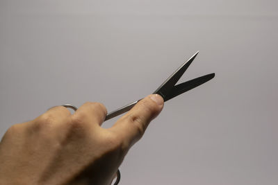 Close-up of hand holding paper over white background