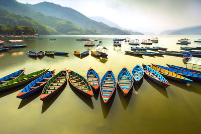Boats moored in lake against sky