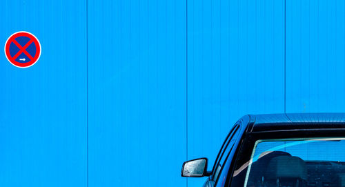 Close-up of car parked by blue wall