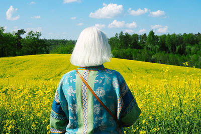 Rear view of a person on grassland against the sky