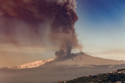 Smoke emitting from volcanic mountain against sky