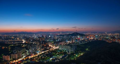 High angle view of illuminated city against sky at night